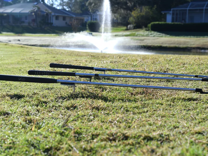 Three clubs propped on Grip Keepers beside a pond